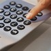 stock photo of a hand dialing a telephone keypad
